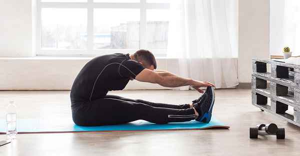 Felnőtt ember nyújtás közben, világos, semleges térben